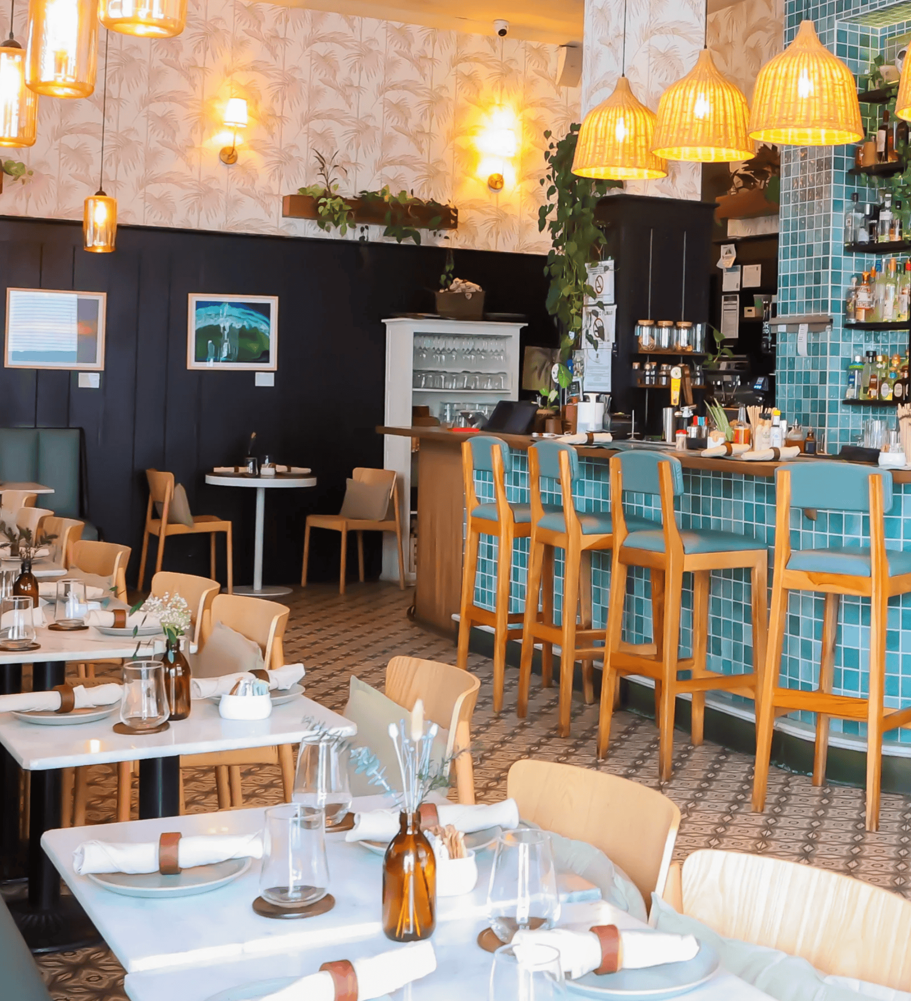 Interior of Mahalo Casco Viejo with turquoise bar tiles, rattan pendant lights, and tropical-modern decor